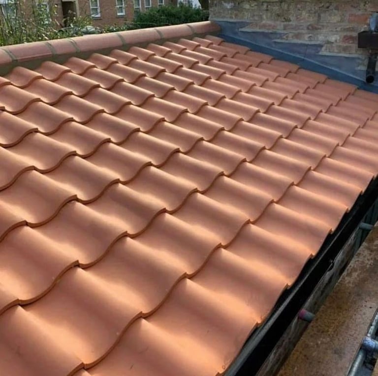 Newly installed terracotta clay roof tiles arranged in overlapping rows on a residential building