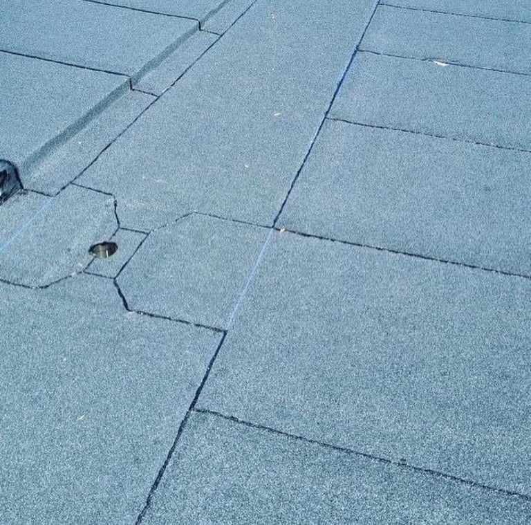 Close-up of a light blue slate or tile floor with grout lines and small debris spots visible